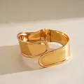 Gros plan d'un large bracelet manchette doré au design géométrique irrégulier - Or