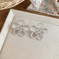 Primo piano di eleganti orecchini a fiore trasparente con zirconi scintillanti. - Stile Fiore / Perno in argento-Bianco