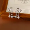 Vista dettagliata di orecchini a C argentati con stelle e croci in zirconi scintillanti - Argento (Perno in argento) / Argento