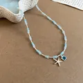 Detail van zomerse ketting met zilveren zeester en vierkante blauwe edelsteen hanger. - Ketting-Blauw