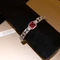 Detailed macro shot of a silver bracelet featuring a square red zircon centerpiece. - Geometric Chain Fashion Bracelet / Silver (Red Stone)