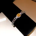 Close-up of elegant bracelet featuring a square yellow cubic zirconia stone. - Geometric Chain Fashion Bracelet / Silver (Yellow Main Stone)