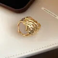Gedetailleerde close-up van de gouden lavatectuur en witte hars op deze vintage ring - Goud-Wit