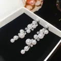 Exquisite detail of elegant resin pearl and rhinestone dangle earrings inside a black jewelry box - Silver Earring Post-White