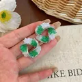 Close-up of geometric stud earrings with green glass and pavé-set zircons - Silver / Green