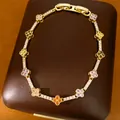 Detailed macro view of a luxury 14k gold plated clover bracelet with multi-colored zircons - Colored Clover Style / Gold