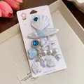Close-up detail of iridescent resin starfish and shell hair clips with imitation pearls - Duckbill Hair Clips / Five-Piece Set / White