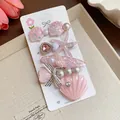 Detailed view of pink resin hair accessories with starfish, shells and pearls on a card - Duckbill Hair Clips / Five-Piece Set / Pink