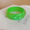 Gedetailleerd overzicht van een felgroene harsarmband met een unieke hobbelige textuur. - Groen