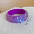 Detail of purple resin bangle with blue glitter and moon pattern on irregular surface - Purple
