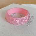 Close-up of pink resin bracelet with irregular textured surface and glossy finish - Pink