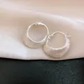 Close-up of vintage 18K gold plated brushed hoop earrings with unique satin finish. - Silver