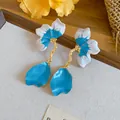 Close-up detail of French-style blue and white petal drop earrings displayed on a tray. - Petal Tassel Style / Blue