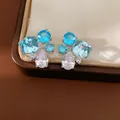 Dettaglio di orecchini a lobo in argento con zirconi blu e pietre trasparenti - Blu