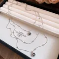 Detalle de un collar de plata de varias capas con colgantes cuadrados oscuros en bandeja - Colgante Cuadrado de Tres Capas (HN12272) / Plata-Gris