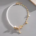 Detail view of an elegant pearl and gold chain necklace with a large jeweled bow. - Gold-White Splicing