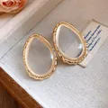 Primo piano di orecchini retrò a goccia dorati con resina trasparente in scatola - Bianco (Perno per orecchino in argento)