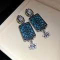 Primo piano di orecchini vintage rettangolari blu con decorazioni in cristallo luccicante - Canna di Fucile - Blu