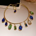 Vue détaillée d'un collier ras du cou doré avec pendentifs en pierres colorées - Or-Bleu-Vert