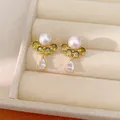 Primo piano elegante di orecchini placcati oro con perla bianca e zirconi verdi pendenti. - Oro-Bianco-Verde (Placcato Oro)