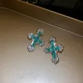 Close-up of cross stud earrings with emerald green and white zirconia stones. - Cross Stud Earrings (HN12399) / Silver-Green