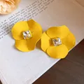 Primer plano de pendientes de flor amarilla con un diamante de imitación cuadrado central. - Amarillo