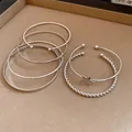 Close-up view of silver-toned retro bangle set featuring star charm and twisted cuff designs. - 6-Piece Set / Silver