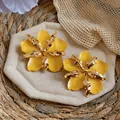 Close-up of large yellow flower stud earrings with gold metallic textured centers - Gold-Yellow