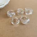 Detail view of five clear resin rings with irregular geometric shapes on beige background - 5 Pieces / White