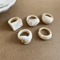 Macro view of chunky resin rings featuring a marble texture and diverse geometric shapes - 5 Pieces / Beige