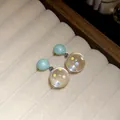 Detailed macro view of resin stud earrings with colorful polka dots inside clear spheres. - Blue-White