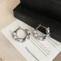 Detail view of silver hoop earrings featuring white pearls and sparkling zircons - Geometric (HE32506) / Silver