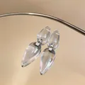 Elegant clear resin teardrop earrings with silver pins reflecting on a mirror surface. - Double Waterdrop Tassel Style (HE32210) / Clear