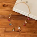 Detailed view of the colorful ladybug and floral charms on a gold-plated vintage necklace. - Gold