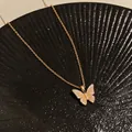 Gold plated butterfly pendant necklace with sparkling zircons on black background - Gold
