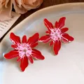 Macro detail view of red and pink enamel flower stud earrings with elegant gold trim - Red