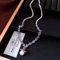 Detailed view of luxury zircon necklace with purple stones and a white pearl pendant - Necklace / Silver-Purple