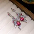 Detailed macro view of elegant silver drop earrings with pink zircon and leaf pattern - Rose Red / Pair / Silver