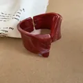 Vista detallada de brazalete de resina roja con diseño retorcido e irregular - Burdeos