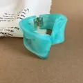 Detalle del brazalete de resina marmoleada verde menta con geometría distorsionada. - Cian