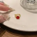 Dettaglio di un earcuff placcato oro 18 carati con uno zircone rotondo rosso brillante. - Pezzo Singolo / Articolo singolo / Oro+Rosso