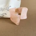 Vista detallada de un brazalete de resina rosa jaspeada con forma geométrica única - Rosa