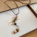 Detailed view of handcrafted wooden beads on this retro ethnic style long necklace - Coffee And White Beaded Style