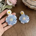 Detalle de pendientes de flor de cristal azul hechos a mano con pétalos de encaje - Blanco-Azul