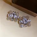 Nahaufnahme von funkelnden übergroßen quadratischen Kristall-Clip-Ohrringen für Luxus-Stil - Clip-Ohrringe / Gold