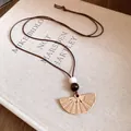 Macro view of bohemian resin fan pendant with wooden beads on brown wax cord necklace. - Fan Dangle / Brown