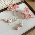 Exquisite close-up of pink fabric flower hair clip featuring elegant long pearl tassels - Pink Lily Of The Valley Style / One Pair / Pink