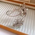 Elegant silver metal arm cuff bracelet featuring a detailed pleated flower design - Pleated Craft Arm Cuff