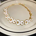Detail view of vintage enamel irregular circle necklace with gold and white finish - Gold White