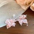 Detailed view of elegant pink petal earrings featuring zircons pearls and tassels - Earring Hooks / Pink